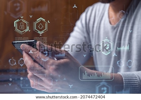 Programmer holding in the hands a smart phone and testing an innovative application to provide a completely new service. Close up shot. Hologram tech graphs. Concept of Dev team.