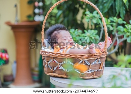 One year old baby Taking pictures of sleeping in a basket, Asian children in Thailand.