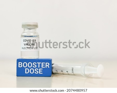COVID-19 VACCINE ampoule with words booster dose and syringe. Royalty-Free Stock Photo #2074480957