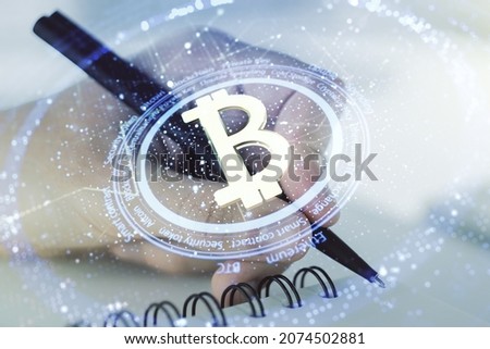 Creative Bitcoin concept with man hand writing in diary on background. Double exposure