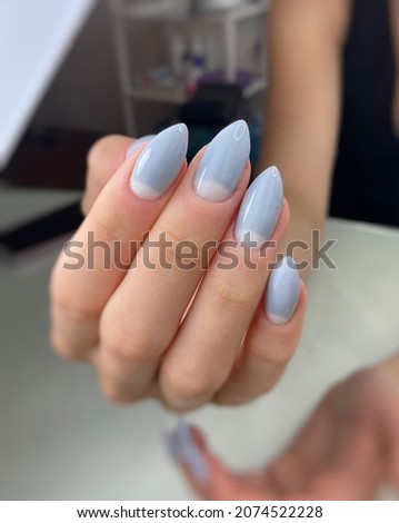  Women's gray manicure with lunar design.Hands of a woman with gray manicure on nails. Manicure beauty salon concept. Empty place for text or logo.