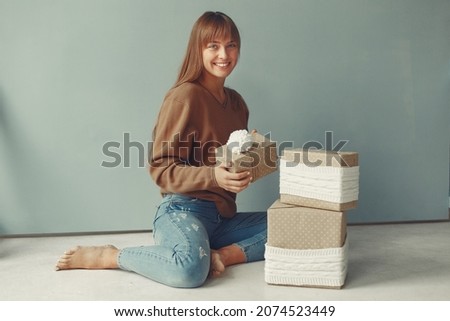 Beautiful girl standing in a studio with presents