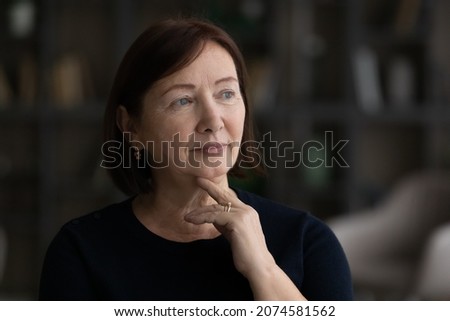 Head shot close up thoughtful melancholic mature woman looking to aside, feeling sad and lonely, pensive upset senior female lost in thoughts, thinking about personal problems, aging process Royalty-Free Stock Photo #2074581562