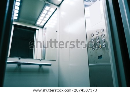 Gray metal elevator with a mirror in front of the door. New elevator inside Royalty-Free Stock Photo #2074587370