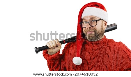 bad Santa, portrait charismatic cheerful bearded man with glasses, woolen red sweater and Santa hat on head with baseball bat in hands isolated on white background, concept of Christmas or holiday 