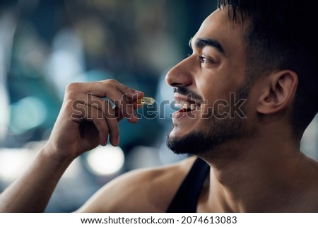 Portrait Of Happy Sportive Arab Man Taking Supplement Capsule, Closeup Shot Of Young Middle Eastern Guy Eating Omega 3 Or Amino Acid Multivitamin Pill, Enjoying Fitness Nutrition, Cropped Royalty-Free Stock Photo #2074613083
