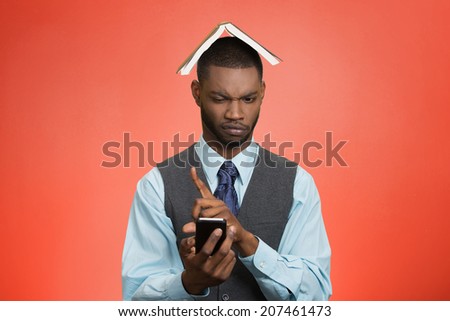 Closeup portrait upset, angry business man, funny looking corporate executive reading e-mail on smart phone, book over head isolated red background. Human face expression, emotion body language 