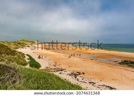 Embleton Bay and Burn with sandy beach with the ruins of Dunstanburgh Castle