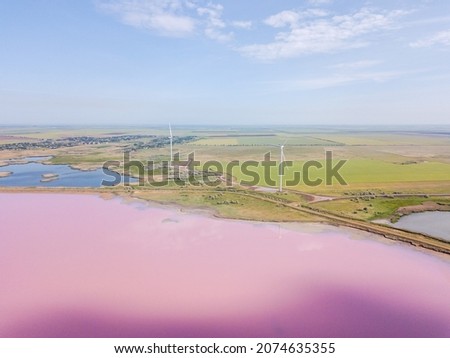 Amazing aerial view of windmills near the pink lake