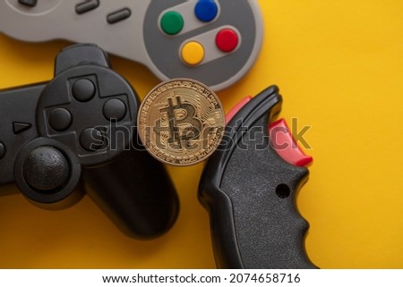 Crypto gaming concept. Video game controller with a bitcoin cryptocurrency coin Royalty-Free Stock Photo #2074658716