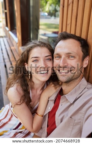 Vertical portrait of young couple taking selfie photo outdoors and smiling at camera while enjoying date together Royalty-Free Stock Photo #2074668928