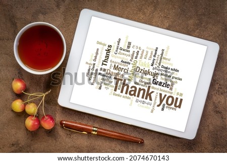 thank you in different languages - word cloud on a  digital tablet with a cup of tea