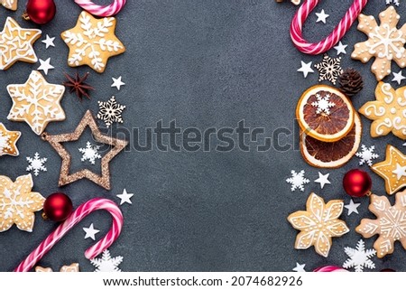 Christmas composition, background made of gingerbread cookies, candy canes and decorations. New Year greeting card. Copy space