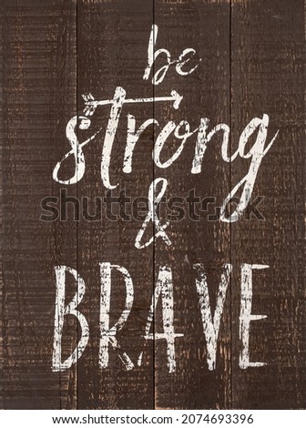 Wood sign with words be strong and brave painted in white.Inspirational be strong and brave concept. Encouragement, health care with positive thinking.