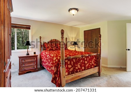 Bright bedroom with carved wood furniture.  View of high pole bed, nightstand, wardrobe