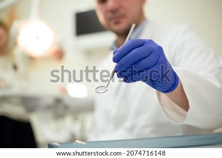Tools in the hands of the dentist. Blue gloves