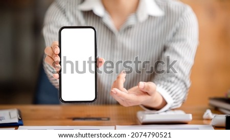 Cropped image of a female freelance translator's hand. holding a blank screen smartphone at work