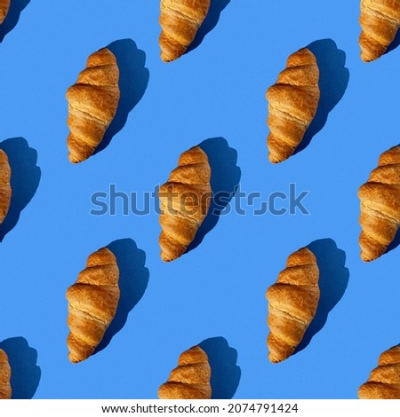 seamless pattern of tasty croissant on a blue background with hard light