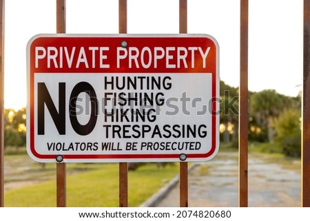 Private property sign hanging on fence gate