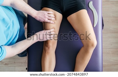 Osteopath performing myofascial release for quadriceps, quads pain releif Royalty-Free Stock Photo #2074843897