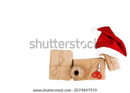 Gift boxes with a Santa  cap, scissors and a ball of thread lie on a white background. isolate