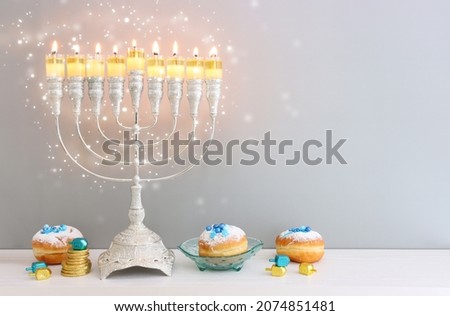 Religion image of jewish holiday Hanukkah background of spinning tops with letters that mean, A 
GREAT MIRACLE HAPPENED HERE, donuts and menorah (traditional candelabra) 