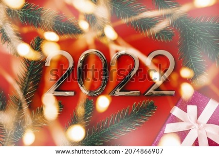 2022 New Year and Christmas celebration. Composition with numbers, blurry lights and gift box