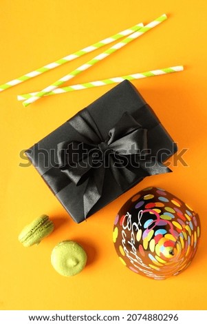Birthday accessories on orange background, top view
