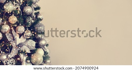 Silver Christmas balls on a fir branch. The image is in soft focus. A banner with space for text.