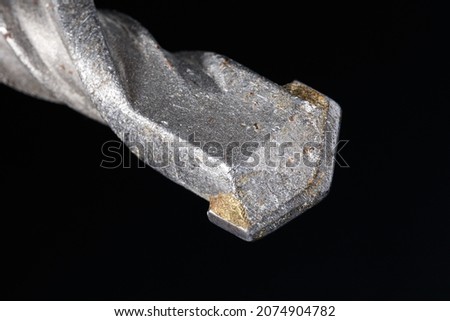 Concrete drill with carbide insert. Close-up on dark background