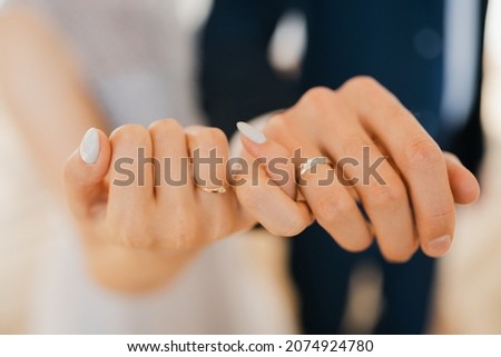 Newlyweds hold hands, hold hands together with little fingers, holding hands together in the foreground, close-up of the hands of a young couple with wedding rings on their ring fingers
 Royalty-Free Stock Photo #2074924780