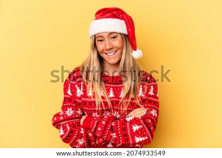 Young caucasian woman celebrating Christmas isolated on yellow background laughing and having fun.