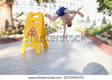 Man didnt notice yellow sign of wet floor plate near swimming pool