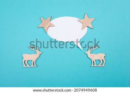 Two cute reindeers talking to each other, speech bubble with copy space, christmas greetings, blue colored background