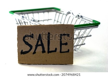 shopping basket with a cardboard sign with the inscription sale. High quality photo