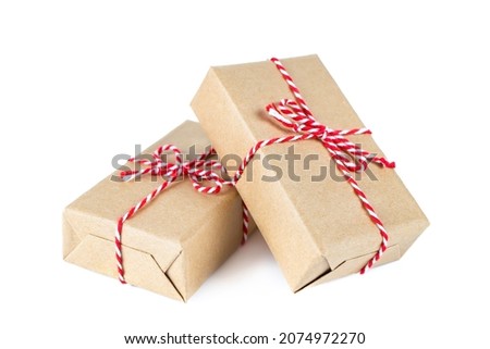 A box, a gift for children for a holiday in a store, a souvenir, for a business office.
Two Christmas and New Year gift boxes wrapped in kraft paper with a red ribbon bow on background isolated.