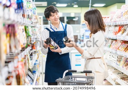 Young woman shopping for groceries at the supermarket Royalty-Free Stock Photo #2074998496