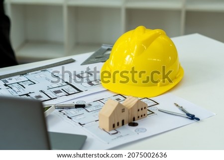 Hard safety helmet hat, construction equipment, blueprint on table in office worker conference site, architect working desk. Engineering tools concept