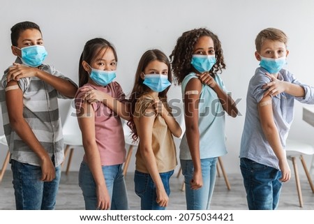 Kids Vaccination Against Covid-19. Diverse Group Of Vaccinated Children Showing Arms With Medical Plaster Bandage After Antiviral Vaccine Injection Standing Over Gray Wall Background Royalty-Free Stock Photo #2075034421