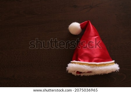 Santa's hat over wooden table for christmas decoration and end of year party.