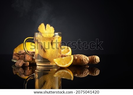 Ginger tea with ingredients. Ginger, lemon, and brown sugar on a black background. Copy space.
