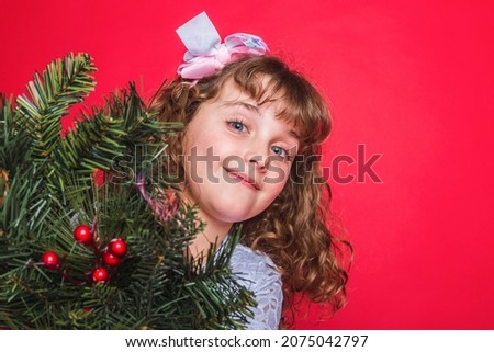 Adorable smiling girl on red background. Christmas concept.