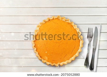 Pumpkin pie on the desk. Seasonal cooking concept. Ingredient for autumn baking.