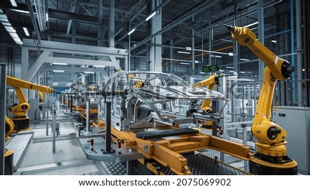 Car Factory 3D Concept: Automated Robot Arm Assembly Line Manufacturing High-Tech Green Energy Electric Vehicles. Automatic Construction, Building, Welding Industrial Production Conveyor. Royalty-Free Stock Photo #2075069902