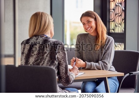 Smiling Female University Or College Student Having Individual Meeting With Tutor Or Counsellor Royalty-Free Stock Photo #2075090356