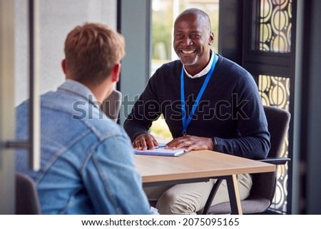 Male University Or College Student Having Individual Meeting With Tutor Or Counsellor Royalty-Free Stock Photo #2075095165