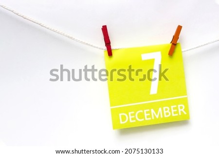 December 7th. Day 7 of month, Calendar date. Paper cards with calendar day hanging rope with clothespins on white background. Winter month, day of the year concept
