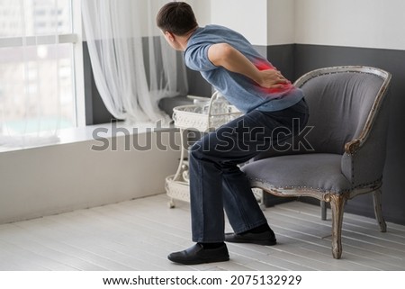 Intervertebral hernia, lumbar pain, kidney inflammation, man suffering from backache at home, spinal disc disease, health problems concept Royalty-Free Stock Photo #2075132929
