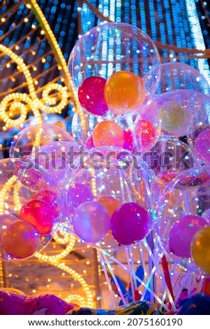 Christmas inflatable balls, decorations with lights. Abstract festive background.Festive multicolored balloons. Colorful holiday decor with balls. New Year, Christmas decoration, inflatable balls.