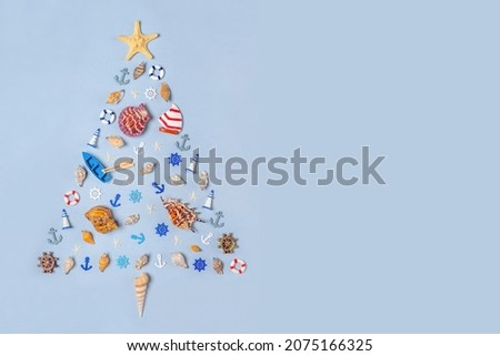 Christmas tree made of decorative ocean items: seashells, starfish, vessels, lighthouses, lifebuoys, steering wheels, anchors. Christmas holidays at sea, travel, cruise, voyage concept. Copy space
